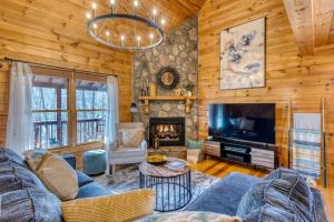 a living room with a couch and a tv and a fireplace at MTN Cabin Sleeps 10 - 5 Mins To Fishing & Camping in Ellijay