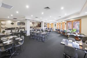 a restaurant with tables and chairs in a room at Quality Hotel Melbourne Airport in Melbourne