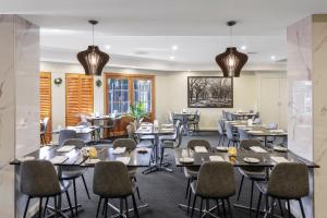 a restaurant with tables and chairs in a room at Quality Hotel Melbourne Airport in Melbourne