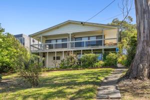 a large house on a hill with a tree at Retro Retreat in Lorne
