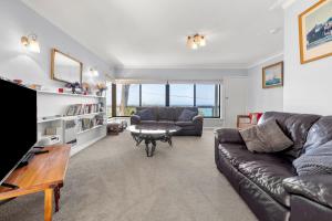 a living room with a couch and a table at Retro Retreat in Lorne +11 photos