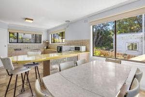 a kitchen with a large dining table and chairs at Retro Retreat in Lorne