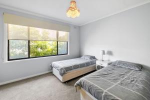 a bedroom with two beds and a window at Retro Retreat in Lorne