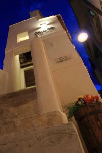 a building with a clock on the side of it at Fondo Vito in Gravina in Puglia