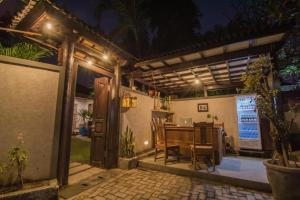 an outdoor dining area with a table and a patio at night at Bale Seminyak in Seminyak