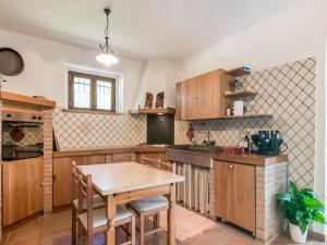 uma cozinha com armários de madeira e uma mesa de madeira em Belvilla by OYO Casale Verbena em Tavoleto