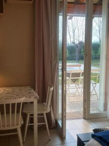 Zimmer mit einem Tisch und Stühlen sowie einer Glasschiebetür in der Unterkunft Room in BB - Casa Belvedere - complimentary Wifi and private parking in Veneto