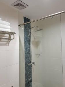 La salle de bains est pourvue d'une douche avec une porte en verre. dans l'établissement TD CAPITAL HOTEL, à Inanam