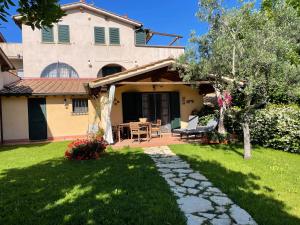 uma casa com um jardim e um pátio em Casa Sophia, piscina con vista mare - ingresso, giardino, barbecue e parcheggio privati by ToscanaTour em Guardistallo