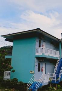 een blauw huis met blauwe trappen aan de zijkant bij Hana Guesthouse in Kuala Tahan