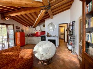 a living room with a couch and a chair at Casa Sophia con piscina - ingresso, giardino, barbecue e parcheggio privati by ToscanaTour in Guardistallo