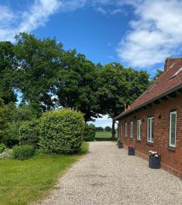 a brick building with a large tree in the background at Gut Koselau Landhaus III 