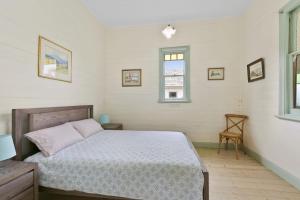 a bedroom with a bed and a window and a chair at Rivernook in Anglesea