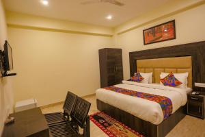 een slaapkamer met een bed, een bureau en een televisie bij FabHotel The Kiara in New Delhi