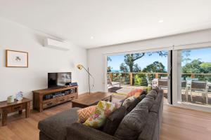 a living room with a couch and a television at Strathlea in Lorne