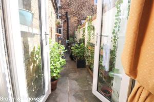 an alley with potted plants on the side of a building at Stylish & spacious 3 bed Victorian house sleeps up to 7 - near O2, Museums, Excel, Mazehill station 12 mins direct into London Bridge in London
