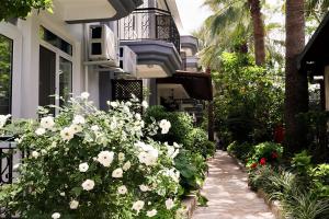 a garden with white flowers in front of a building at Canada Hotel & Bungalows in Cıralı