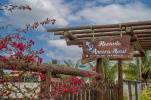 a sign at the entrance to a resort with flowers at Recanto Ancora Azul - Taipu de Fora in Barra Grande