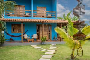 a blue house with a palm tree in front of it at Recanto Ancora Azul - Taipu de Fora in Barra Grande +37 photos