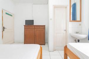 Baño blanco con lavabo y cama. en Pall Inn Puncak Mitra RedDoorz, en Bogor 34 fotos más