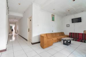 una sala de estar con un sofá y una mesa en Pall Inn Puncak Mitra RedDoorz, en Bogor