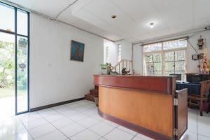Un bar en una habitación con un mostrador. en Pall Inn Puncak Mitra RedDoorz, en Bogor