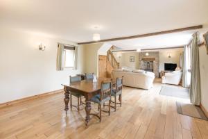 a dining room with a table and a living room at Groves Fishleigh in Hatherleigh