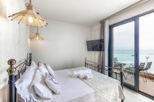 a bedroom with a bed with a view of the ocean at Alkionides Apartments in Polychrono