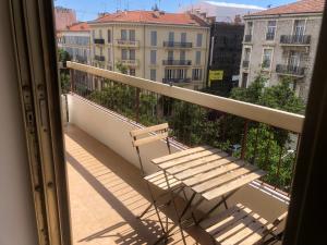 a bench on a balcony with a view of buildings at 2 pièces Nice Malaussena in Nice