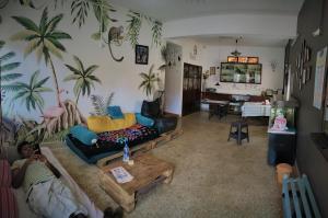 una sala de estar con palmeras en la pared en Monkey Mind Hostel, en Margao 28 fotos más