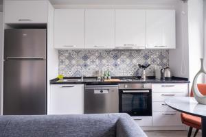 a kitchen with white cabinets and a stainless steel refrigerator at Stella Stays Comfortable 1 BDR Etiler in Istanbul