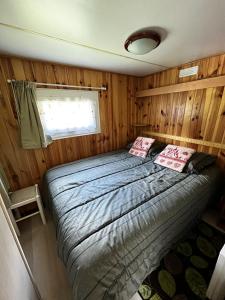 - une chambre avec un lit dans une pièce dotée de murs en bois dans l'établissement Bungalow de 2 chambres avec jardin amenage et wifi a Cauterets, à Cauterets