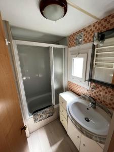 y baño pequeño con lavabo y ducha. en Bungalow de 2 chambres avec jardin amenage et wifi a Cauterets, en Cauterets