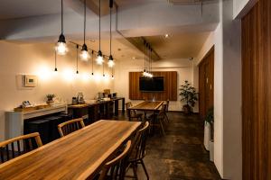 a restaurant with wooden tables and chairs and lights at ETAVIA Yufuin Kinrinko in Yufu