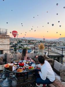 a group of people sitting around a table with food at Chelebi Cave House Hotel in Göreme