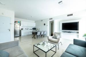 a living room with a couch and a table at Pool side luxury suite at Royal Park-New Listing in Eilat