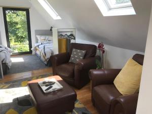 a living room with two chairs and a bed at The Cartlodge in Hollesley