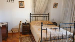 a bedroom with a bed and a desk and a chair at Arhodico Simou mansion in Kambos +61 photos