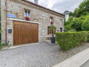 a brick house with a wooden garage door at Charming Cottage in Anseremme with Fenced Garden in Dinant