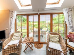 a living room with two wicker chairs and a table at Charming Cottage in Anseremme with Fenced Garden in Dinant