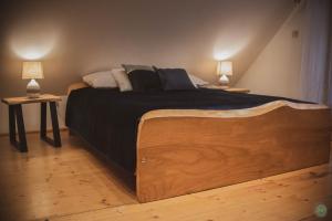 a large bed in a room with two lamps at Stara Chata w Beskidach in Żabnica