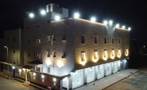 a building with lights on top of it at night at أجنحة عبدالعزيز للوحدات السكنية in Sulţānah