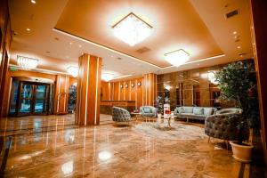 Regal Inn Badamdar Hotel في باكو: لوبي فيه كنب وكراسي في مبنى