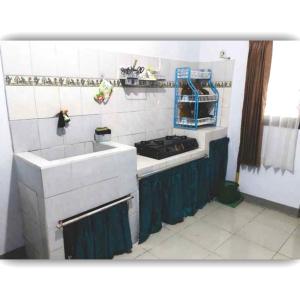 uma cozinha com um lavatório e um fogão em Situ Gede Indah HOMESTAY em Tasikmalaya