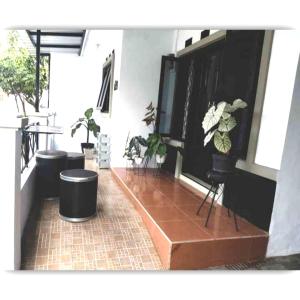 uma sala de estar com vasos de plantas e uma televisão em Situ Gede Indah HOMESTAY em Tasikmalaya