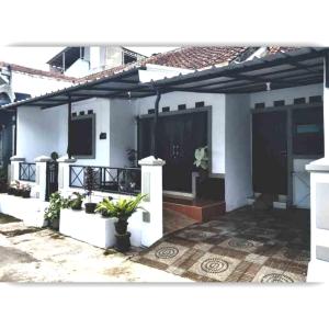 uma casa branca com um pátio com plantas em Situ Gede Indah HOMESTAY em Tasikmalaya