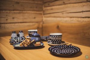 a table with blue and white cups and plates of food at Stara Chata w Beskidach in Żabnica