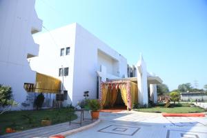a white building with a gate in front of it at Meera Madhav Resort in Vrindāvan