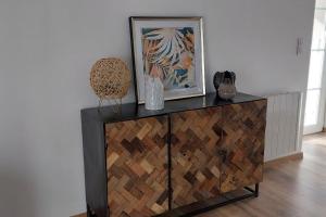 a dresser with a painting on top of it at Gîte chez Marianne- la halte Jurassienne in Montmorot