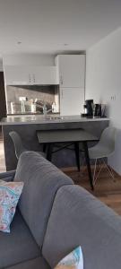 a kitchen with a table and a couch in a living room at Gîte chez Marianne- la halte Jurassienne in Montmorot